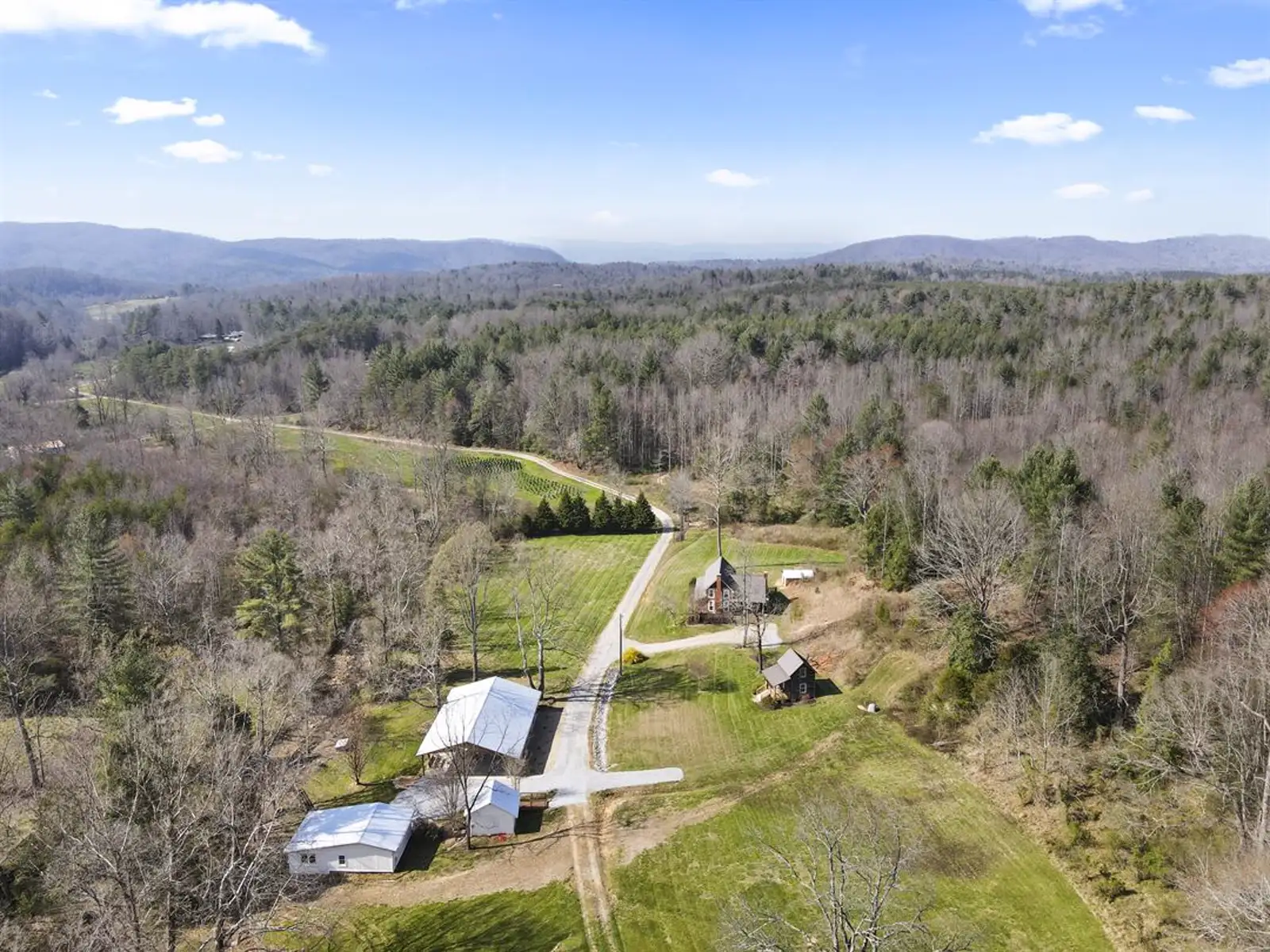 Aerial view of Stillwater Meadows — the pavilion, fields and Blue Ridge foothills on 42 private acres in Boomer, NC