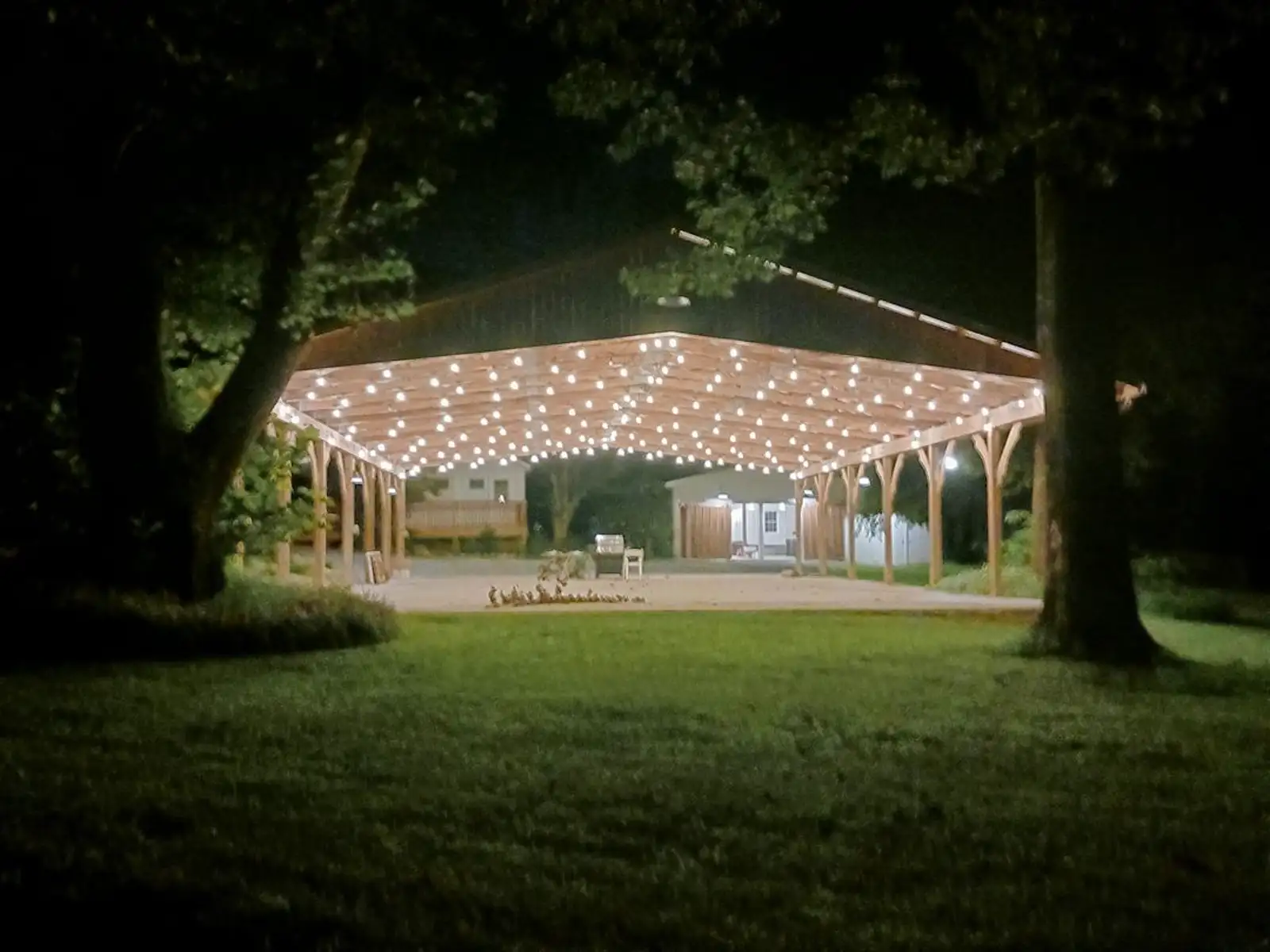 The Stillwater Meadows pavilion at night, glowing with string lights and draping