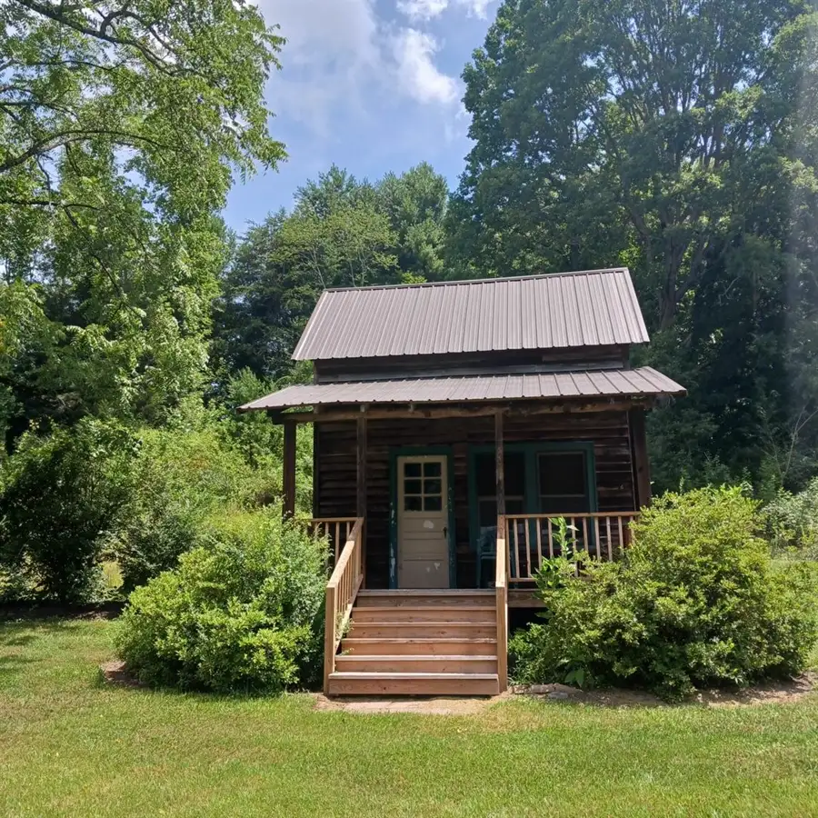 A rustic cabin building with porch at Stillwater Meadows